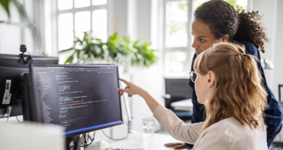 Two women looking at a computer screen.